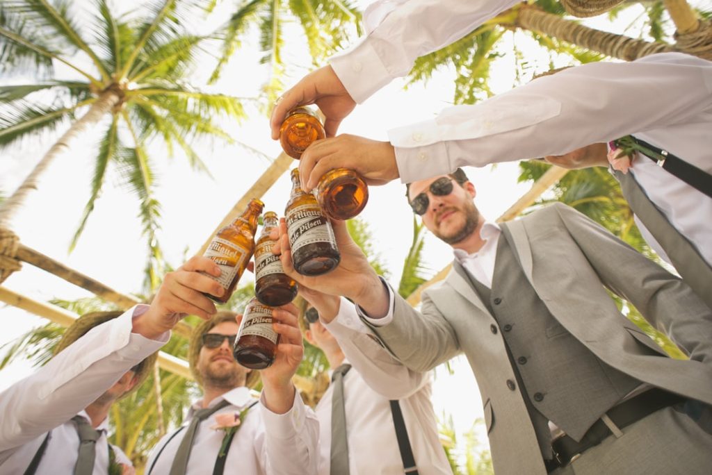 low-angle-of-men-holding-beer-bottles-and-having-a-toast-cld1i8hp008