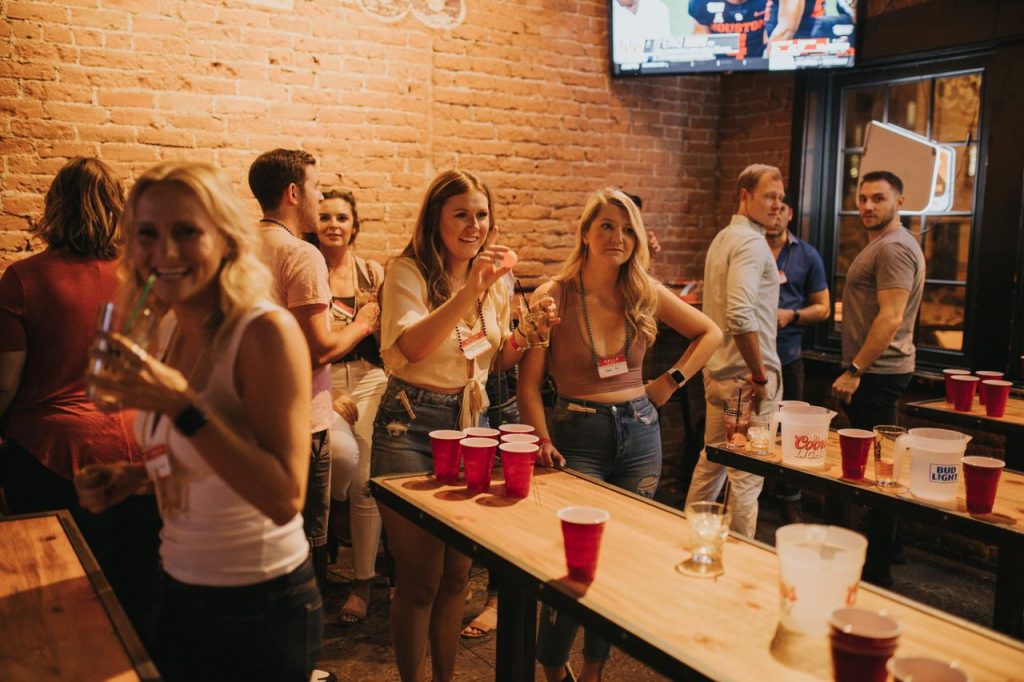 Energetic social gathering at a Denver pub featuring a lively beer pong game and cheerful participants.